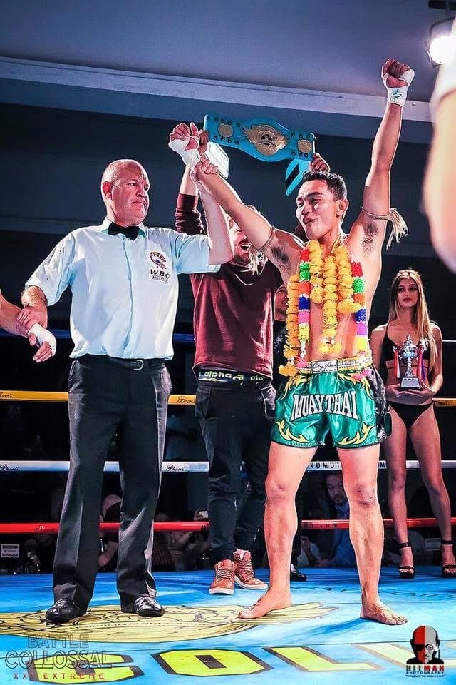 Surasak holding a championship belt